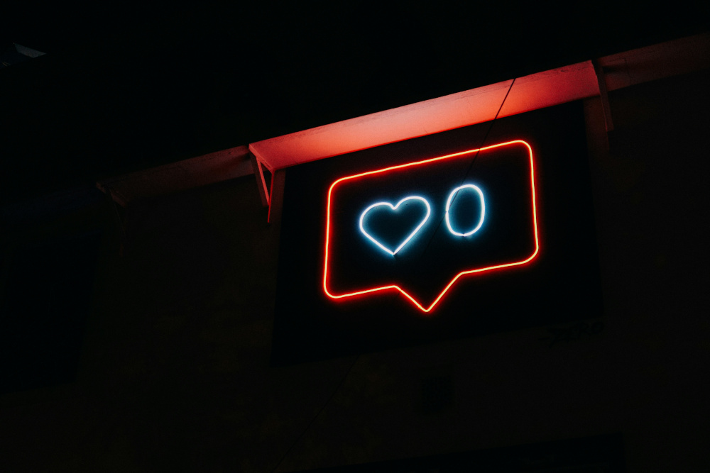 a neon sign showing a social media likes counter with zero likes