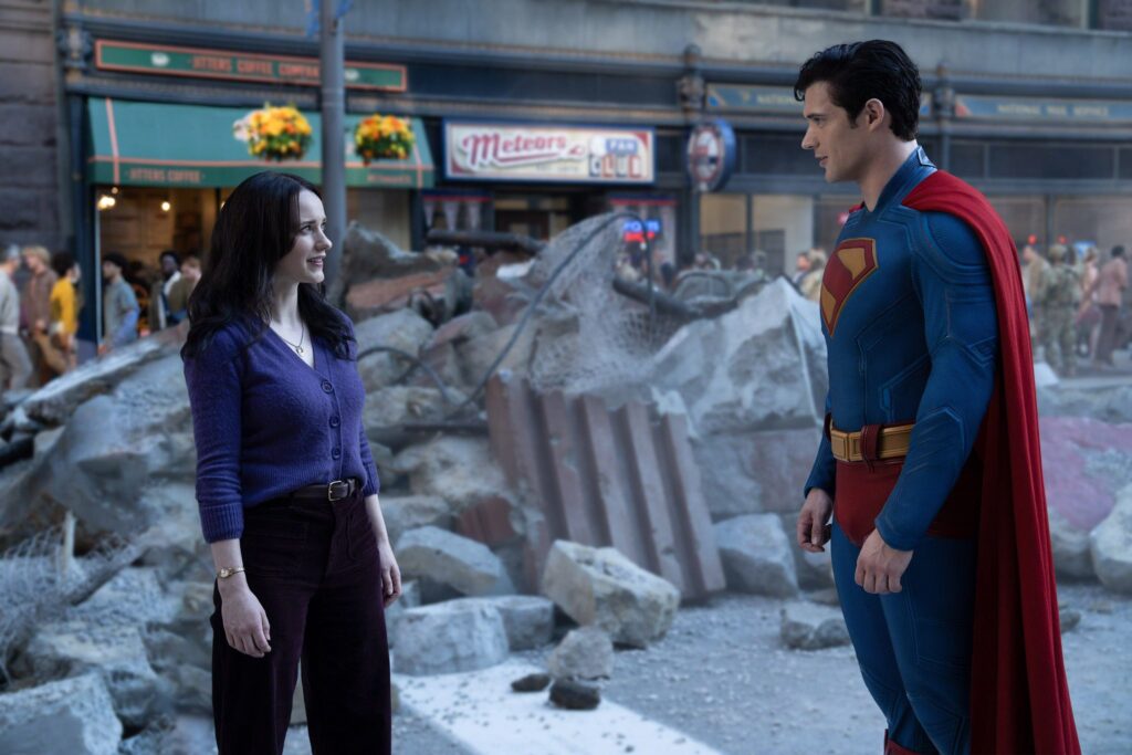 Rachel Brosnahan as Lois Lane faces David Corenswet as Superman against a backdrop of grey rubble.